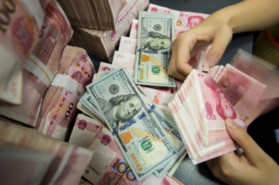 중국 장수성 난퉁시의 한 은행에서 직원이 중국 100위안과 미국 100달러 지폐를 세고 있다. /사진=AFP