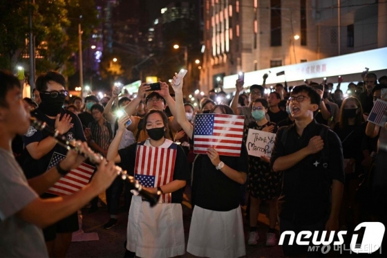 (홍콩 AFP=뉴스1) 우동명 기자 = 14일(현지시간) 홍콩 시민들이 미국 의회가 홍콩 인권법을 통과해줄 것을 촉구하는 집회에서 성조기를 흔들며  시위 주제가인 '홍콩에 영광을' 부르고 있다.  © AFP=뉴스1  <저작권자 © 뉴스1코리아, 무단전재 및 재배포 금지>