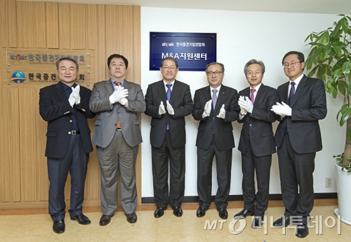 2014년 12월 5일 서울 마포구 중견기업연합회 대회의실에서 열린 '한국중견기업연합회 M&A지원센터' 출범식에 참석한 당시 한정화 중소기업청장(사진 왼쪽 네번째)이 이종태 퍼시스 사장(왼쪽 첫번째), 우오현 SM그룹 회장(왼쪽 두번째), 강호갑 중견련 회장(왼쪽 세번째), 최진식 SIMPAC 회장(왼쪽 다섯번째) 과 함께 박수를 치며 개소식을 축하하고 있다. 중견련 M&A지원센터는 당시 침체된 중견·중소·벤처 M&A 시장 활성화를 통해 중견기업의 구조조정 및 지속성장을 지원한다는 취지로 신설됐다. /사진제공=중견련
