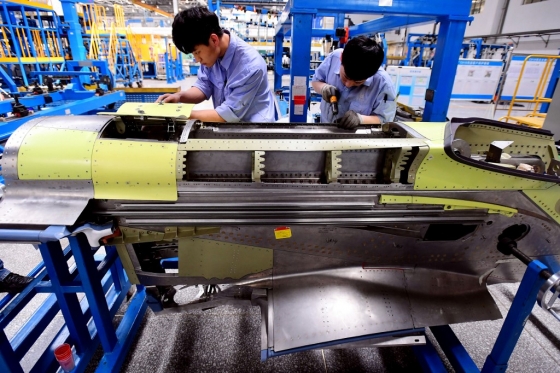 중국 랴오닝성 선양에 위치한 중국 국영 항공기 제작사 코맥(COMAC) 공장에서 직원들이 자체 개발 항공기 'C919'의 엔진 부품을 살펴보고 있다. /사진=AFP