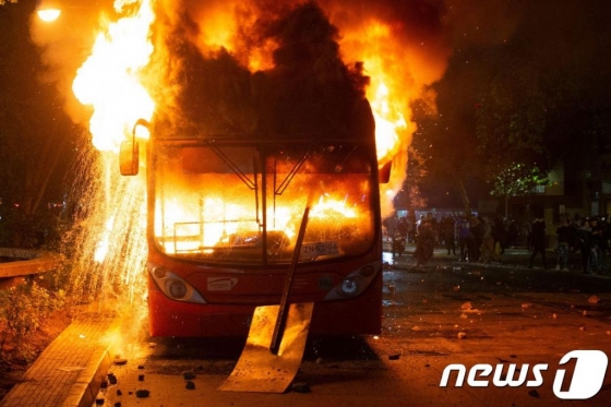20일 (현지시간) 산티아고에서 지하철 요금 인상으로 촉발된 칠레 반정부 시위대의 방화로 버스가 불에 타고 있다. /AFP=뉴스1