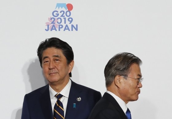 문재인 대통령이 지난 6월 28일 인텍스 오사카에서 열린 G20 정상회의 공식환영식에서 의장국인 일본 아베 신조 총리와 악수한 뒤 행사장으로 향하고 있다. /사진=AFP