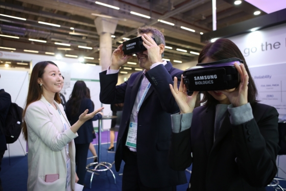 'CPhI 2019' 참가자가 삼성바이오로직스 부스를 방문해 가상현실(VR) 기기로 삼성바이오로직스 3공장을 체험하고 있다./사진=삼성바이오로직스 <br><br> 