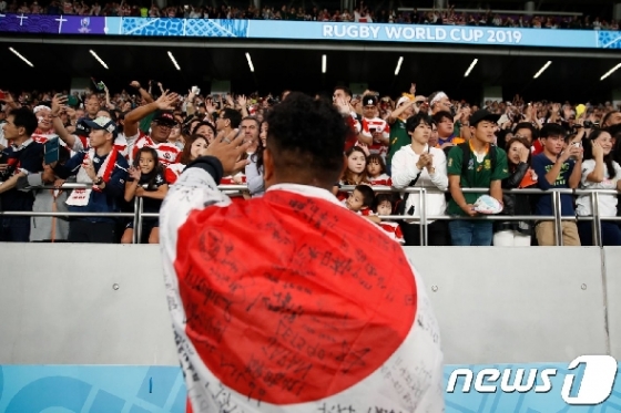 일본 도쿄 스타디움에서 열린 2019 럭비 월드컵에서 한 선수가 일본 국기를 몸에 감은 채 관객들에게 인사를 하고 있다. © AFP=뉴스1