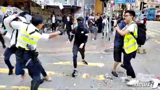 11일(현지시간) 온라인에 유포된 동영상 속에서 한 홍콩 경찰관이 시위 현장에서 다가오는 시위자를 향해 총을 겨누고 있다. 현지 언론은 이날 오전 홍콩 사이완호 지역에서 시위 희생자 차우츠록을 추모하는 시위가 열린 가운데 시위대 한 사람이 경찰이 발사한 실탄에 맞아 쓰러져 병원으로 이송돼 치료를 받고 있다고 전했다. 2019.11.11. /로이터=뉴스1