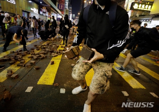 홍콩에서 시위 중 사망한 대학생 차우츠록을 추모하는 시위가 이어진 가운데 10일(현지시간) 시위대가 보도블록을 집어들고 있다./사진=뉴시스