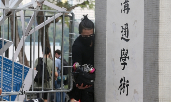 홍콩 중문대학 캠퍼스 내에서 한 시위 참여자가 방독면을 들고 바리케이드를 지나가고 있다. /사진=로이터