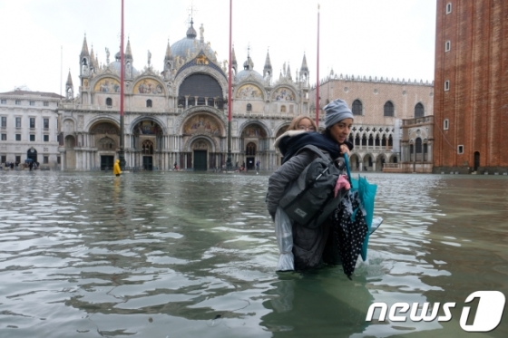 12일(현지시간) 물에 잠긴 이탈리아 북부 베네치아 산마르코 광장을 한 모녀가 걷고 있다. /로이터=뉴스1
