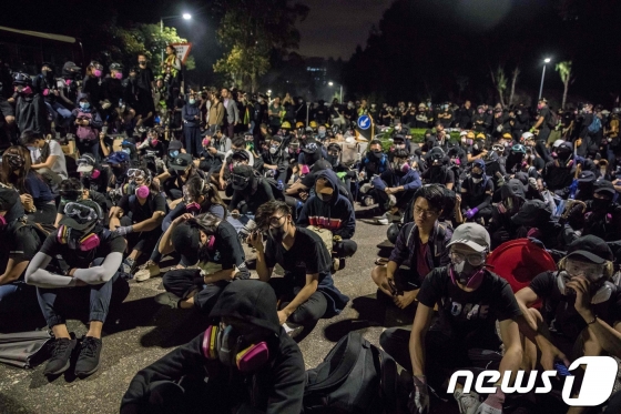(홍콩 AFP=뉴스1) 우동명 기자 = 12일(현지시간) 시위 참여자가 경찰이 쏜 실탄에 맞아 중태에 빠지는 사건이 발생한 가운데 홍콩 시위대가 홍콩 중문대학에 모여 연좌시위를 하고 있다.   ⓒ AFP=뉴스1  