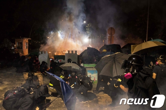 (홍콩 AFP=뉴스1) 우동명 기자 = 12일(현지시간) 시위 참여자가 경찰이 쏜 실탄에 맞아 중태에 빠지는 사건이 발생한 가운데 홍콩 시위대가 진압경찰과 격렬하게 충돌을 하고 있다.  ⓒ AFP=뉴스1  