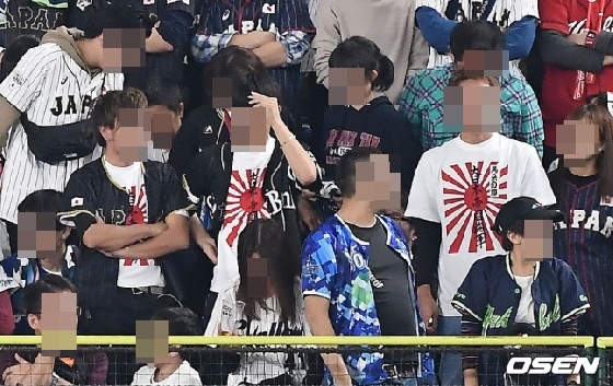 남성 관중 3명이 16일 도쿄돔에서 욱일기가 새겨진 티셔츠를 입고 경기를 지켜보고 있다. /사진=OSEN