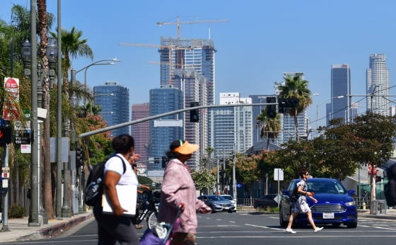 캘리포니아주 로스앤젤레스 도심에 아파트가 건설되고 있는 가운데 주민들이 길을 걷고 있다/사진=AFP