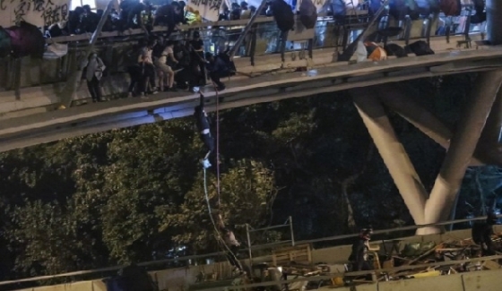 시위대가 홍콩 이공대 옆 육교에서 밧줄을 타고  탈출을 시도하고 있다.  다리 아래는 고속도로다. - SCMP 갈무리