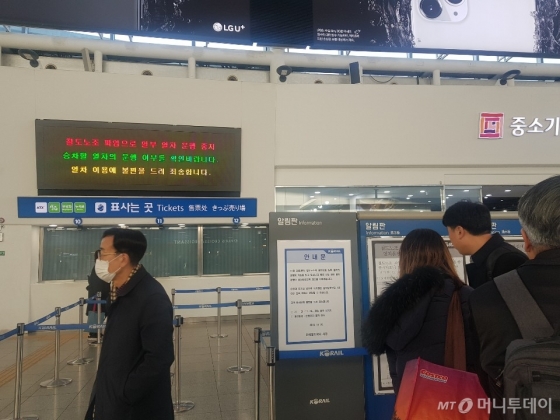 20일 오전 서울역에서 고속철도(KTX)이용객들이 열차 운행 중지와 관련한 안내문을 확인하고 있다. /사진=조한송 기자