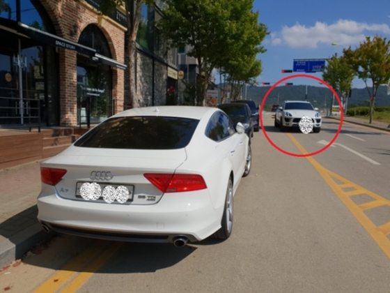 지난 9월 30일 오후 '주정차 금지 표지판'에도 불구하고 불법으로 주차된 차량들을 피해 한 차량(오른쪽 흰색 차량)이 중앙선을 넘어 달리고 있는 모습 2018.10.01/사진=뉴시스