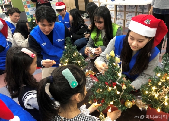 현대글로비스 임직원들이 지난 6일 서울 구로구 ‘함께하는 한숲 영문지역아동센터’를 찾아 아이들에게 선물을 전달하고 함께 크리스마스 트리를 만들고 있다.  /사진제공=현대글로비스