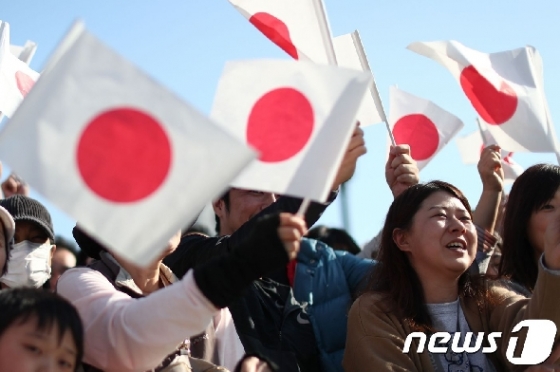 지난달 10일 일본 국기를 흔들며 일왕 행차를 환영하고 있는 일본 시민들.  © AFP=뉴스1