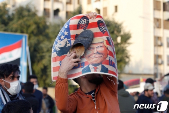 1일(현지시간) 이라크 바그다드 주재 미국 대사관 앞에서 시위대가 도널드 트럼프 대통령 그림을 펼쳐든 채 항위시위를 벌이고 있다. © 로이터=뉴스1