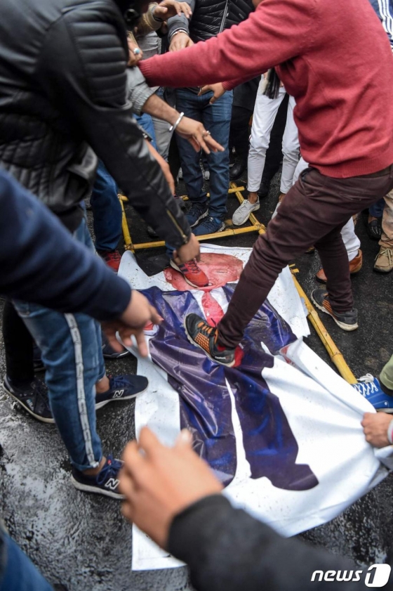 7일(현지시간) 인도 뉴델리의 미국 대사관 근처에서 거셈 솔레이마니 이란 혁명수비대 쿠드스군 사령관의 죽음에 항의하는 시위대들이 도널드 트럼프 미국 대통령의 사진을 짓밟고 있다./사진=뉴스1