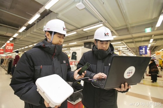 KT 네트워크부문 직원들이 경기도 안양시 홈플러스 매장 내에 고성능 광중계기를 설치하고 5G 서비스 품질을 확인하고 있다./사진=KT