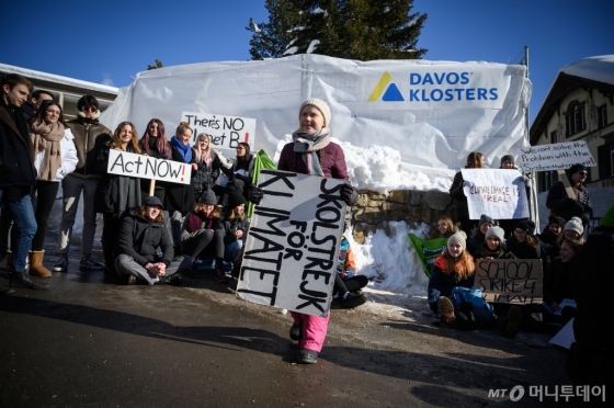 지난해 1월에 열린 다보스 포럼에서 환경운동가 그레타 툰베리가 '기후 변화를 위한 학교 파업' 피켓을 들고 기후 변화 대책을 촉구하고 있다/AFP