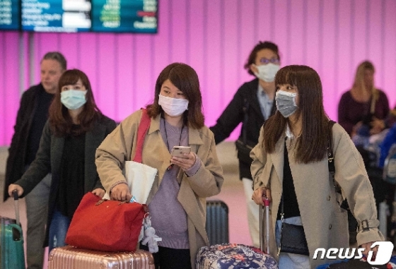 22일(현지시간) 미국 LA국제공항에 도착한 여행객들이 마스크를 착용한 채 이동하고 있다. © AFP=뉴스1