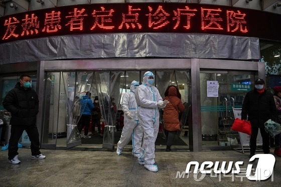 25일 중국 우한의 적십자병원에서 방호복과 마스크를 입은 의료진이 이동하고 있다. © AFP=뉴스1