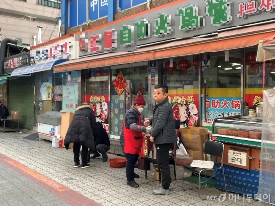 29일 서울 구로구 가리봉동 차이나타운에서 한 손님이 담배를 피며 식료품을 사고 있다/사진= 임찬영 기자