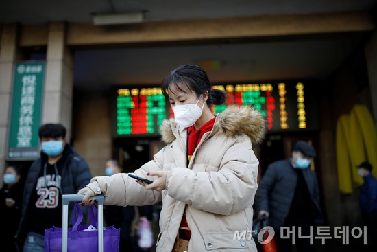 30 일 중국 베이징에서 새로운 코로나 바이러스가 발생했다. 얼굴에 마스크를 쓰고있는 한 여성이 베이징 기차역을 빠져 나가고 있다. /로이터=뉴스1