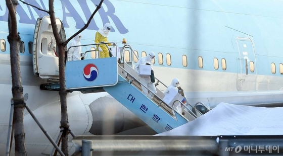 중국 우한 거주 한국 교민 수송에 투입된 전세기가 도착한 31일 서울 강서구 김포국제공항에서 검역관들이 내리고 있다. / 사진=이기범 기자 leekb@