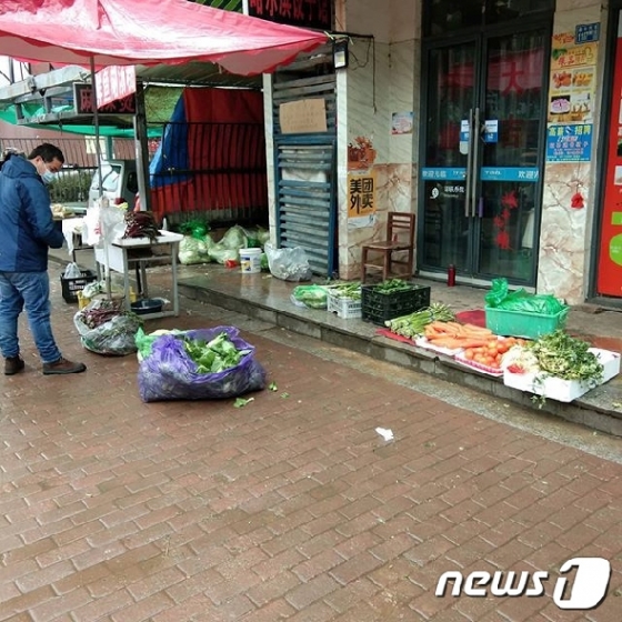 한 남성이 우한시의 거리에서 채소를 보고 있다. © 로이터=뉴스1