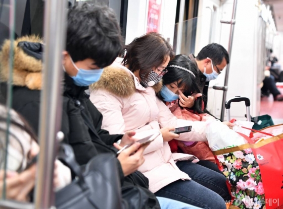 [시안=신화/뉴시스]27일(현지시간) 중국 산시성 시안의 한 지하철 탑승객들이 마스크를 착용한 채 이동하고 있다. 구를 소독하고 있다. 시안시 관계자는 신종 코로나바이러스의 확산을 막기 위해 지하철역, 관광지, 공공 지역 등의 소독 및 검역을 강화했다고 밝혔다. 2020.01.28.