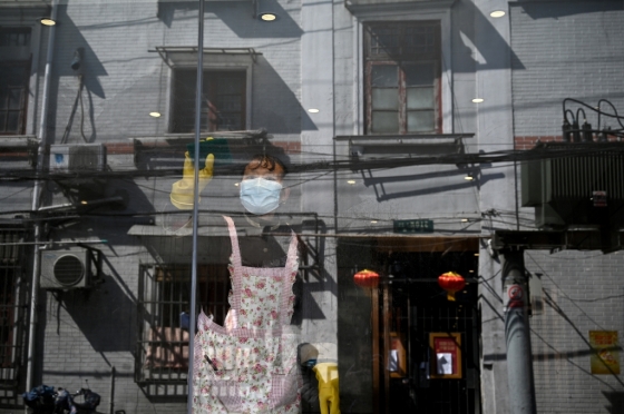 중국 상하이에서 한 노동자가 마스크를 낀 채 창문을 닦고 있다./사진=AFP