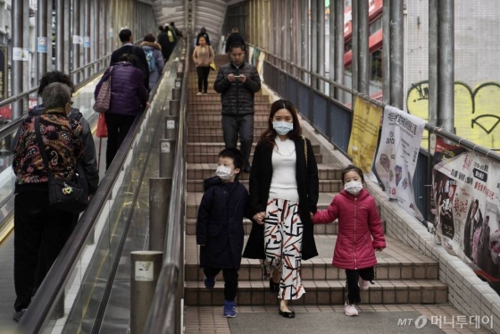 [홍콩=AP/뉴시스]19일(현지시간) 마스크를 쓴 한 가족이 홍콩 시내 센트럴 거리를 걷고 있다. 러시아 정부는 신종 코로나바이러스 감염증(코로나19)에 관한 성명을 내고 “오는 20일부터 노동, 교육, 관광 등의 목적으로 러시아로 들어오는 중국인의 입국을 일시 중단한다"라고 밝혔다. 2020.02.19.