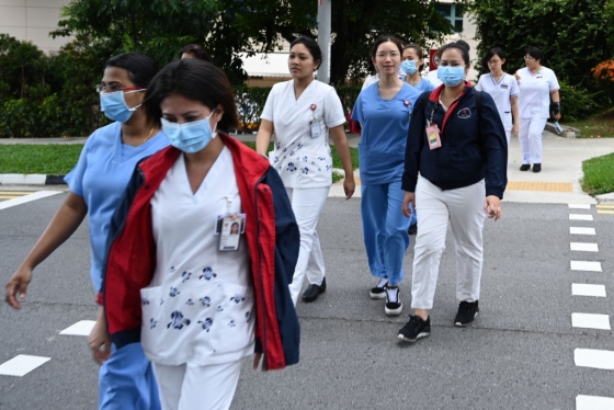 마스크를 쓴 의료진들이 싱가포르 국립 감염병센터 건물로 걸어가고 있다./사진=AFP