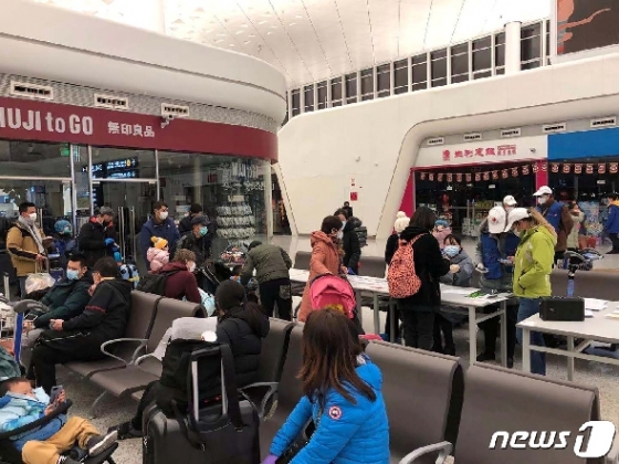 우한을 빠져나오기 위해 비행기 탑승을 기다리고 있는 사람들 ©로이터=뉴스1