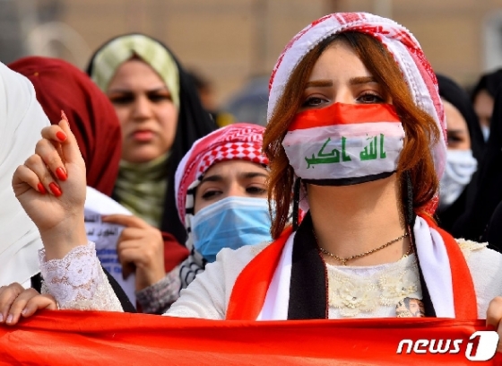 이라크 나자프에서 시민들이 마스크를 쓴 채 반정부 시위를 벌이고 있다. © AFP=뉴스1