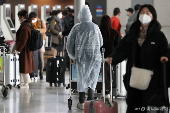 '코로나19' 국내 확산이 빠르게 진행되고 있는 가운데 26일 인천국제공항 제1터미널 출국장에서 우비를 착용한 한 중국인이 발걸음을 옮기고 있다. /사진=이기범 기자