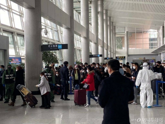 중국 산둥성 웨이하이국제공항에서 25일 방역요원들이 제주항공편으로 입국한 승객들을 버스에 태우고 있다. (사진=독자 제공) /사진=뉴시스