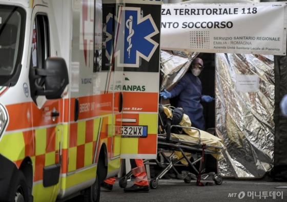 [피아첸차=AP/뉴시스]27일(현지시간) 이탈리아 북부 피아첸차 병원 응급실 옆에 설치된 시민보호청 텐트에서 구급차에 실려온 한 여성이 들것에 실려 내리고 있다. 이탈리아 시민보호청은 27일 기준 코로나19 사망자 수가 17명, 누적 확진자 수는 650여 명으로 늘었다고 밝혔다. 이탈리아는 이란과 함께 아시아 외 지역에서 최근 코로나19 확진자가 급격히 늘어난 국가로 꼽힌다. 2020.02.28.