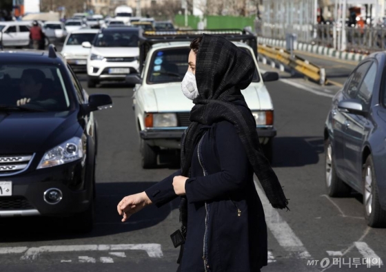[테헤란=AP/뉴시스]4일(현지시간) 이란 테헤란 북부의 한 교차로에서 마스크를 쓴 여성이 길을 건너고 있다. 이란 보건부는 4일 정오 기준 신종 코로나바이러스 감염증(코로나19) 확진자가 586명 더 늘어 모두 2천922명이 됐으며 사망자는 15명 증가해 지금까지 92명이 숨졌다고 밝혔다. 2020.03.05.