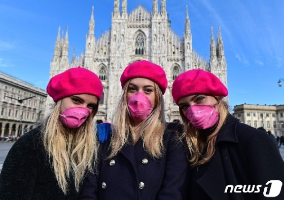 8일 국제 여성의 날을 맞아 여성들이 분홍색 마스크를 쓴 채 밀라노 거리를 걷고 있다. © AFP=뉴스1