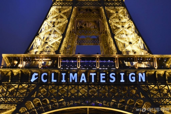 2015년 12월12일(현지시간) 프랑스 파리에서 열린 유엔 기후변화협약 당사국총회에서 지구온난화에 대응하기 위해 전 세계가 참여하는 보편적 기후변화 협정이 진통 끝에 최종 채택됐다. 이날 파리 에펠탑에 '클라이밋사인(CLIMATESIGN)'이라는 로고가 비춰지고 있다. 당시 협약에서 190여 국가들은 현재의 지구 평균 온도 상승폭을 산업혁명 당시보다 2℃ 이하로 낮추도록 시스템을 재정비하는 데 합의한 바 있다. / 사진제공=뉴시스/신화