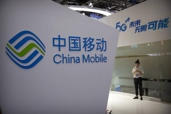 【베이징=AP/뉴시스】중국 최대 이통통신 업체인 차이나모바일(中國移動)은 2025년 전 세계  5세대(5G) 서비스 이용자는 16억명에 달하고, 중국 5G 사용자는 그 3분1을 차지할 것이라고 밝혔다. 지난달 31일 베이징의 한 박람회장에서 한 여성이 차이나모바일 로고 앞에서 스마트폰을 보고 있다.  2019.11.04