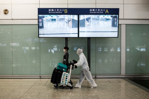 19일(현지시간) 홍콩 쳅락콕 국제공항에서 한 입국자가 방호복으로 전면 무장한채 공항내를 걸어가고 있다./사진=AFP통신
