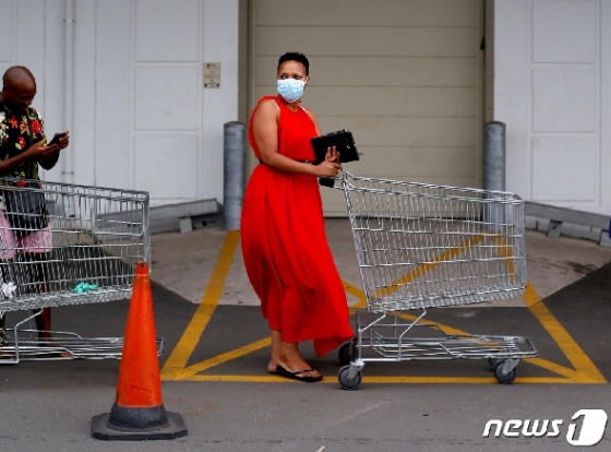 27일(현지시간) 남아프리카공화국의 한 여성이 음식을 사기 위해 줄을 서고 있다. © 로이터=뉴스1