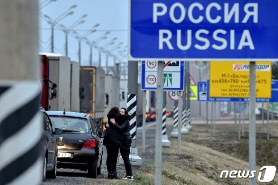 러시아와 벨라루스 국경 폐쇄를 하루 앞둔 29일(현지시간) 한 가족이 국경 인근에서 작별 인사를 하고 있다.  © AFP=뉴스1