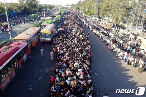 28일 (현지시간} 코로나19 확산으로 국가봉쇄령이 내려진 인도 뉴델리의 버스 터미널에 고향으로 돌아가려는 수십만명의 근로자들이 아수라장을 이루고 있다. © AFP=뉴스1 © News1 우동명 기자