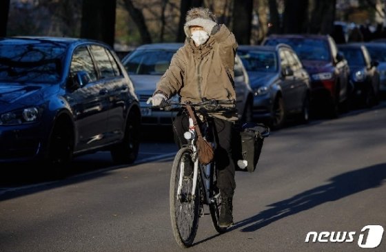 독일의 한 거리에서 마스크를 쓴 여성이 자전거를 타고 있다. © AFP=뉴스1