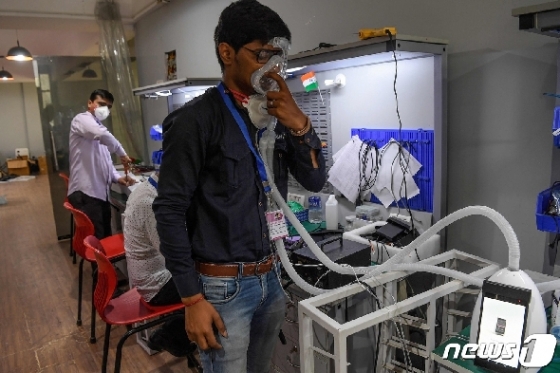인도의 한 의료기기업체 직원이 인공호흡기 시제품을 사용해보고 있다. © AFP=뉴스1